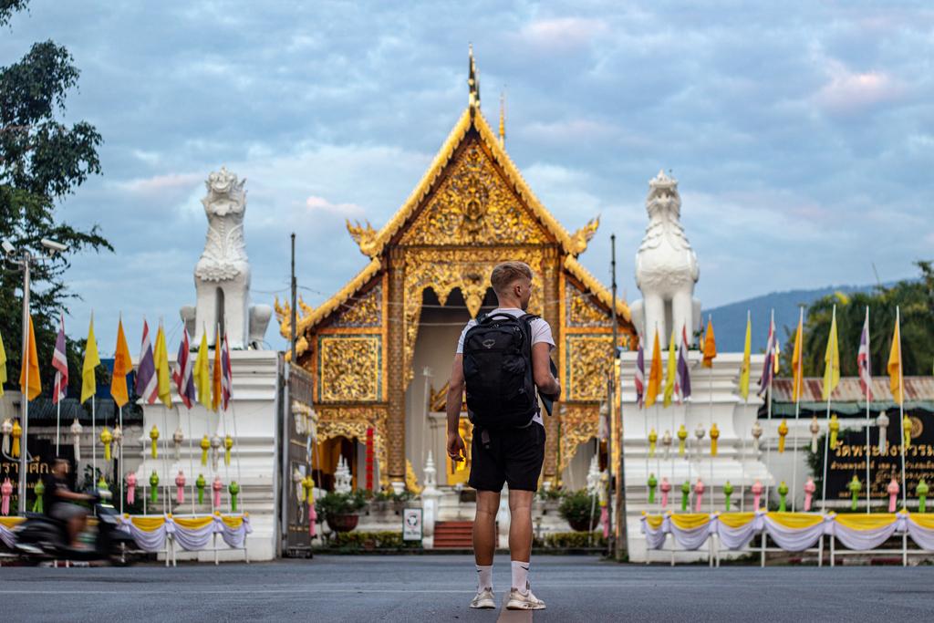 Junge vor einem Tempel in Bangkok mit Backpack