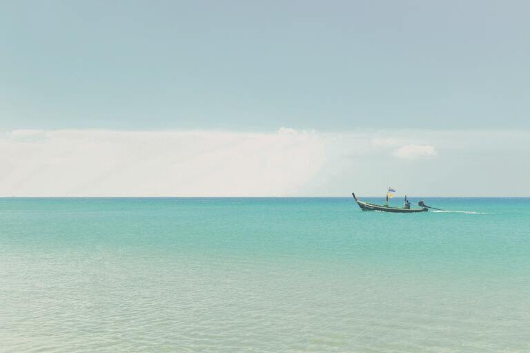 Kamala Beach in Phuket mit einem kleinen Boot