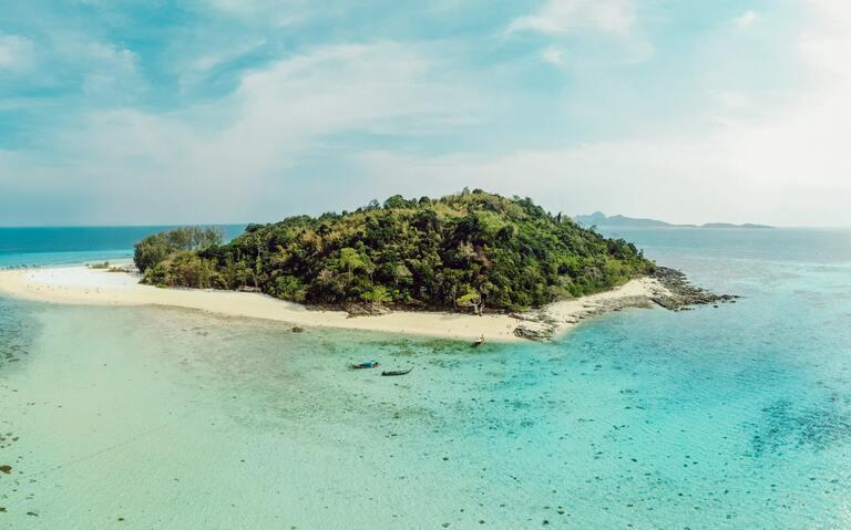 Eine Insel der 4000 Island Tour mit kristallklarem Wasser und weißem Sand
