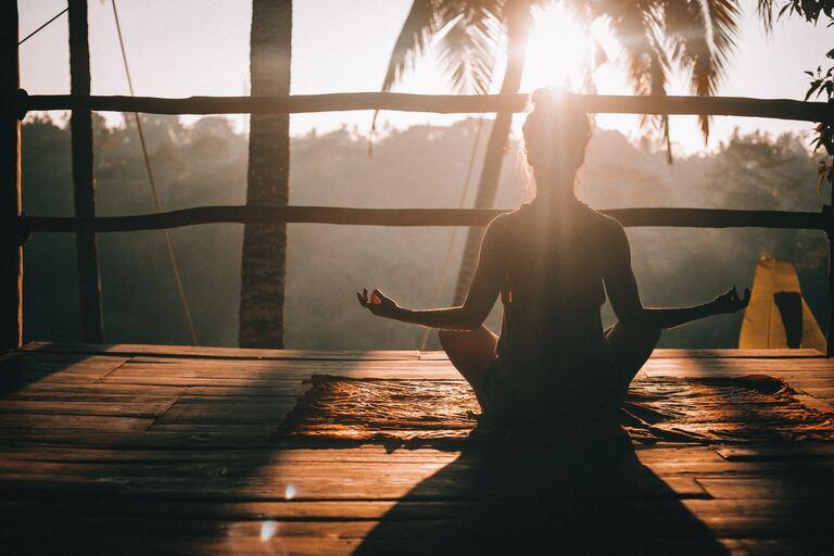Junges Mädchen auf Bali das Yoga macht beim Sonnenaufgang